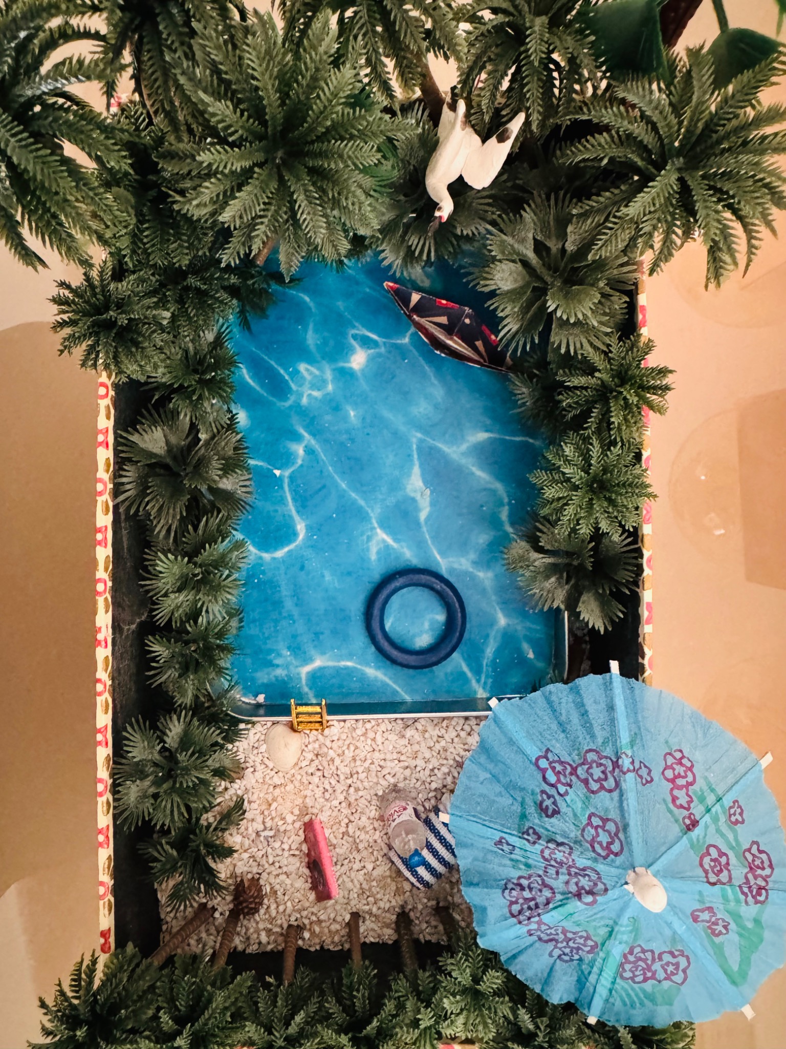 A5-Box mit Miniaturpool, Pflanzen, Boot und Sonnenschirm